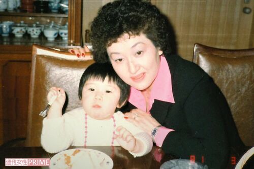 自宅で数子先生と一緒に食事をしている幼いころのかおりさん。数子先生の優しいまなざしが印象的