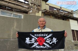 全壊の自宅前で志團からもらったタオルを広げる茂串至孝さん＝千葉・鋸南町