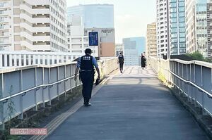 選手村の周辺をパトロールする警官。後ろ姿からは暑さによる疲労がみてとれる