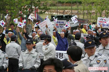 シュプレヒコールする光復会のメンバーとそれを取り囲む警察隊