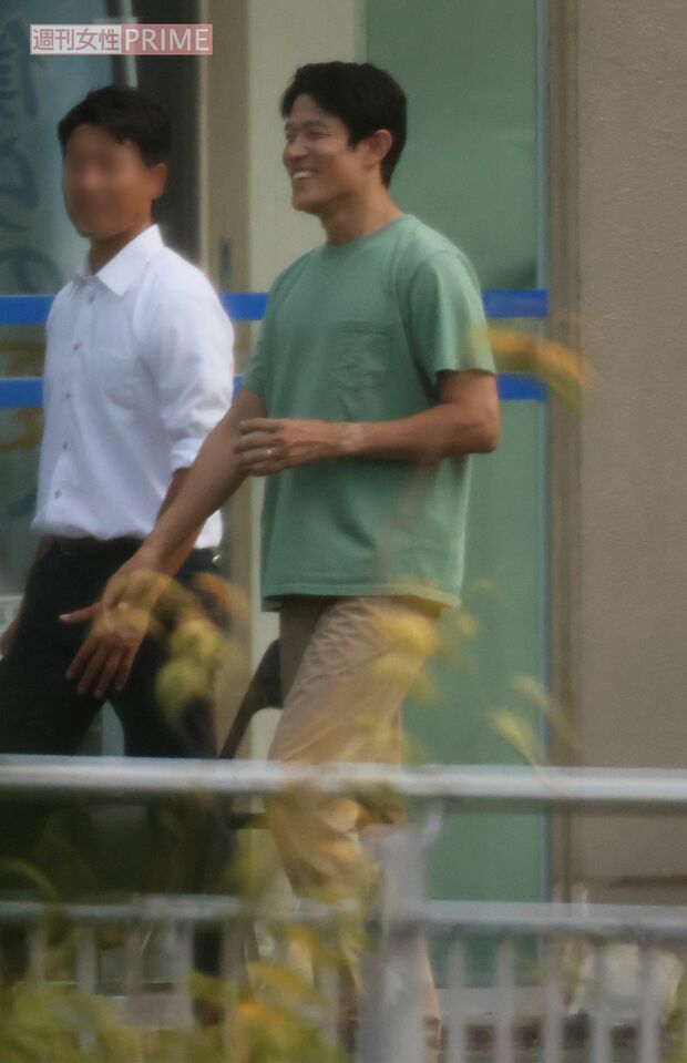 スタッフと談笑しながらロケ現場を移動する鈴木。左腕にはくっきりと時計焼けが（9月11日）