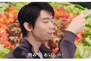 口角がキュッと上がった“あざとかわいい”表情をしながら『味の素』のCMに出演する羽生(公式HPより)