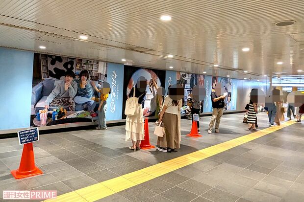 渋谷駅地下通路に展示されたKing&Prince『なにもの』巨大広告と記念撮影をするファン