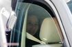 3月7日、夫が逮捕された件で直撃取材を受ける三浦瑠麗氏。車内でも笑みを浮かべている