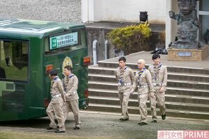 憂鬱げな面持ちでバスへ向かうメインキャスト5人