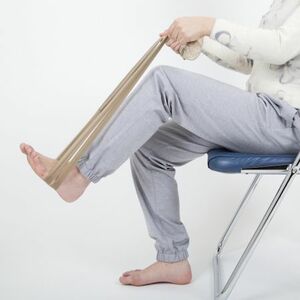 【1】パンストを結んでチューブ状にし、両手で持って、足の裏に通す。イスに座ったまま、グッと踏み込む。この状態をキープするだけでも、腰まわりの筋肉を鍛えられる。