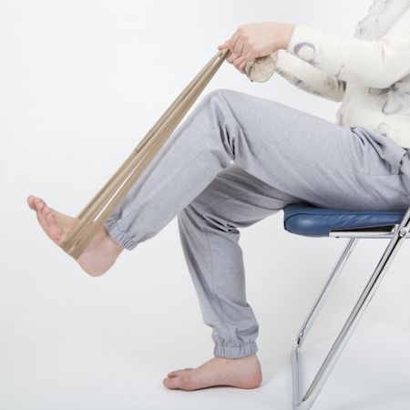 パンストを結んでチューブ状にし、両手で持って、足の裏に通す。イスに座ったまま、グッと踏み込む。この状態をキープするだけでも、腰まわりの筋肉を鍛えられる。