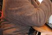 カウンターテーブルにひじをついてスマホを見ているジェシカさん。豊満な肉体の彼女は施設長にいちばんからかわれたという