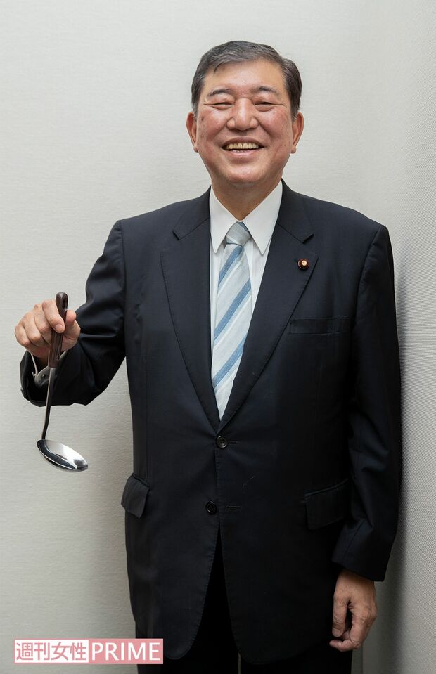 カレーを煮込む「おたま」を持ったポーズをお願いすると、周囲から「先生、大丈夫ですか!?」と制止する声が。しかし、慣れた手つきでおたまを受け取って、快く撮影に応じてくれた。石破さん、いい笑顔です!（カメラマン談）