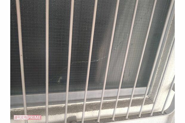 事件現場となったマンションの一室。窓ガラスにヒビが入っていて