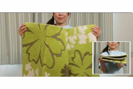 玄関マット枕の作り方（1）裏地がついた硬めの玄関マット（50×90センチ程度）を3つに折る（写真提供／16号整形外科）