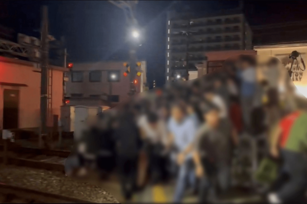 大阪府『阪急十三駅』で遮断機から身を乗り出し車両を撮影しようとする撮り鉄(Xで拡散されている動画のスクリーンショット)