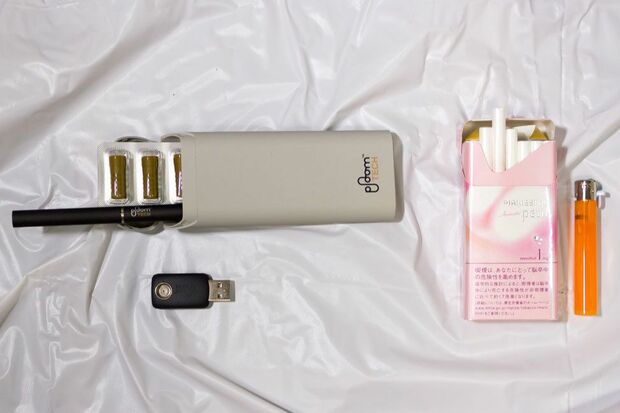 右側が従来の紙巻きタバコとライター。左側が専用たばこカプセル、プルーム・テック本体、専用ケース、充電用USBアダプター