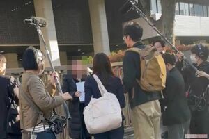 訴訟の判決日、東京地裁でマスコミに囲まれ取材を受けるマイコさん