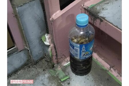 容疑者の自宅玄関前には真っ黒い液体の入ったペットボトルにタバコの吸い殻がいくつも浮かんでいた