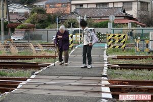杖をついて山の根踏切を渡る高齢者を心配し、住民が付き添う姿も（※写真は一部加工）