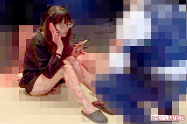 事件直後にエントランスで撮影されたとする写真。撮影者に取材を申し込んだが返答はなかった。容疑者のスマホも素足も血まみれ（※モザイク処理は編集部でしています）