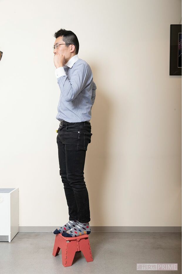 【3】右足も上げて台に乗る。転倒に気をつけながら右足も同様に台に乗せる。このとき腕が下がってこないように90度以上を保つ。