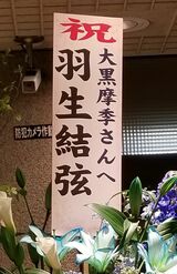 かなり大きな祝い花で、五輪でも着用したSPの際の衣装に似た色みだ