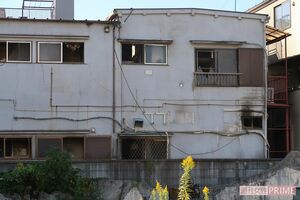 燃えたアパートの裏側。窓ガラスは割れ、すすが残っている