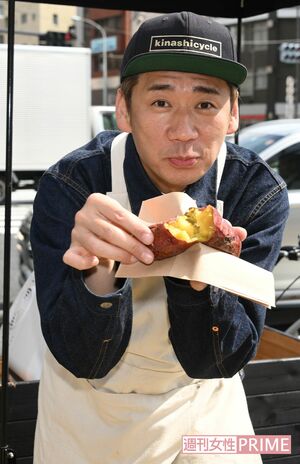 自作の焼き芋を手に持ってカメラに応えるやまもとまさみ