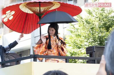 和傘に加え日傘をさして移動車に乗る栗山千明の周りには、撮影自粛を呼びかけるスタッフが