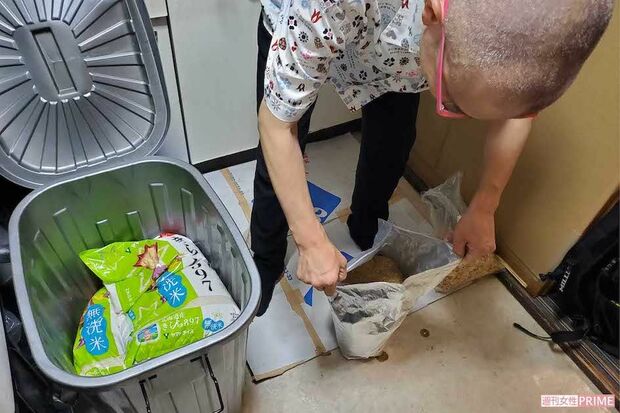 食糧庫のポリバケツから取り出した乾燥キャベツの袋を開くきららさん