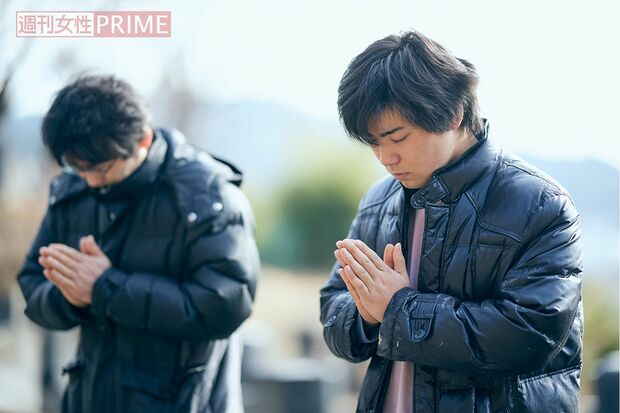 家族の眠るお墓に手を合わせる千葉孝幸さん（奥）と雄貴さん（撮影／廣瀬靖士）
