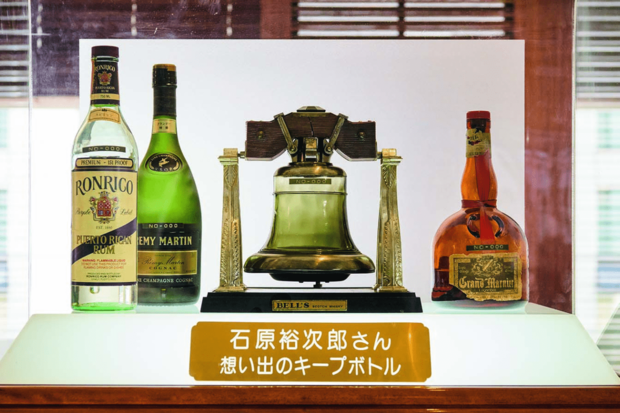 裕次郎さん思い出のキープボトル。左からロンリコ（ラム酒）、レミーマルタン（ブランデー）、デキャンタに入ったベル（ウイスキー）、グラン・マルニエ（オレンジ・リキュール）