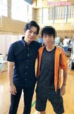 避難所となっている矢野南小を訪れ、ツーショット撮影に応じる松本。右は宮原さん