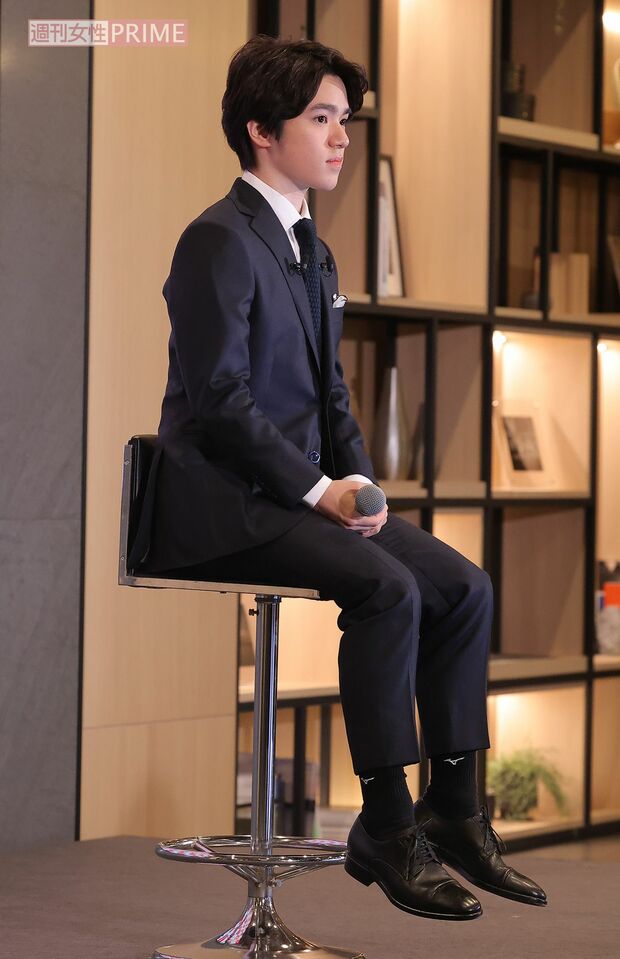 会見で157センチという身長に関する質問に答えた宇野昌磨。椅子に座ったその足は浮いていた