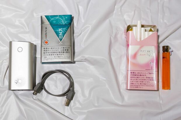 右側が従来の紙巻きタバコとライター。左側がネオスティック、グロー本体、充電用ケーブル