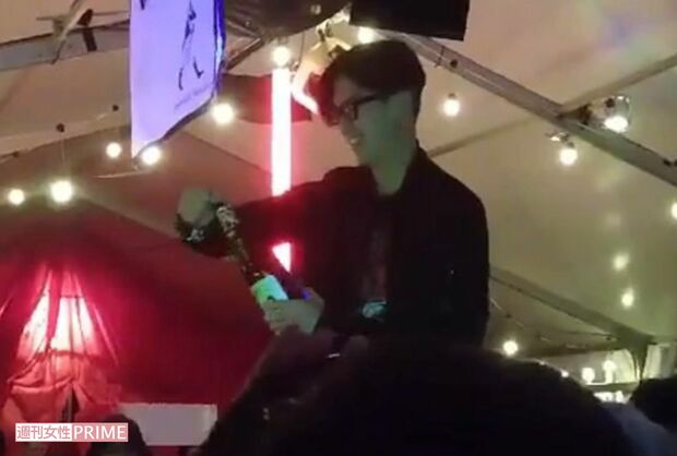 結婚祝いのボトルを開ける松田