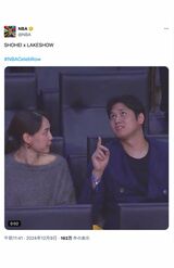NBAの観戦中、スクリーンに映ったことに気づき照れ笑いする大谷夫妻（NBA公式Xより）