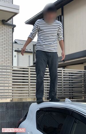 X教員の車にのぼりふざけるB教員（関係者提供）