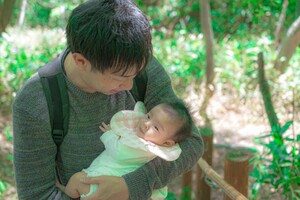 赤ちゃんを抱え森に入る父親(写真はイメージです)