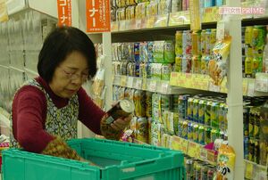 缶入り飲料を慣れた手つきで並べる水村さん。真剣な表情だ