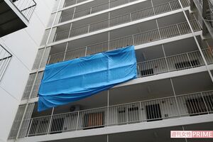 捜査中の現場のマンション。ブルーシートに覆われ