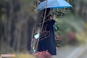 雨の中傘をさして車を待つ風間俊介の妻と長男（'19年2月）