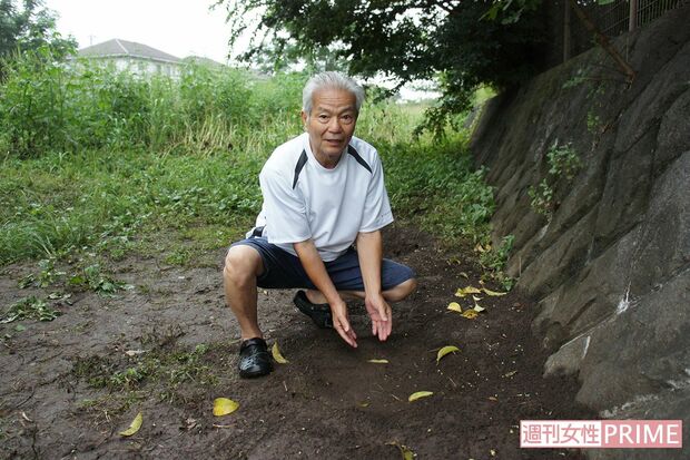 男児が埋まっていた場所で、土をどけるシーンを再現する保延さん