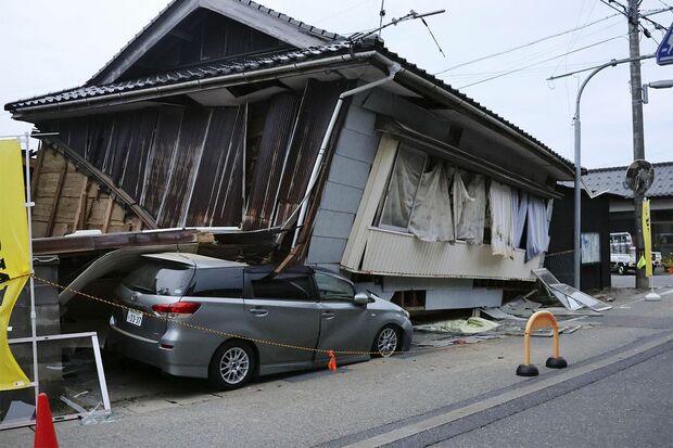 5月5日、石川県能登地方で起こった震度6強の地震で民家が倒壊し、車を押しつぶした　写真／共同通信社