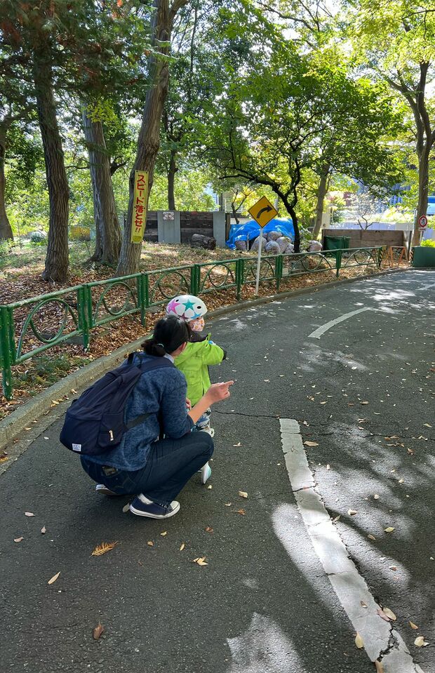 杉並児童交通公園で娘に自転車の乗り方を教える真田さん。園内ではスタッフの方が交通指導をする場面も