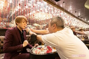 指導役のなつさん（左）のタバコに火をつけるいしだ壱成（右）