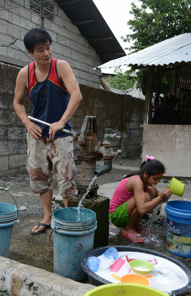 吉岡さんの朝は、井戸で水をくむことから始まる。鶏が鳴く中、慣れた手つきでハンドルを動かしていた