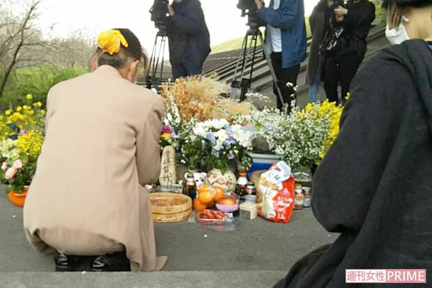河渡橋西詰の下に置かれた献花台で手を合わせるアイさん