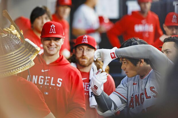ホームランを打った後、兜を同僚にかぶせて大谷翔平はカメラを構えるポーズ。おなじみになっている　写真/共同通信社