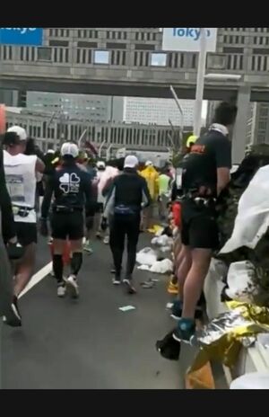 植栽に向かって立ち小便をするランナーたち、足元を見るとずらっと並んでいることがわかる(Twitterより)