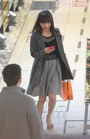 スマホを手に嬉しそうな新藤まなみ