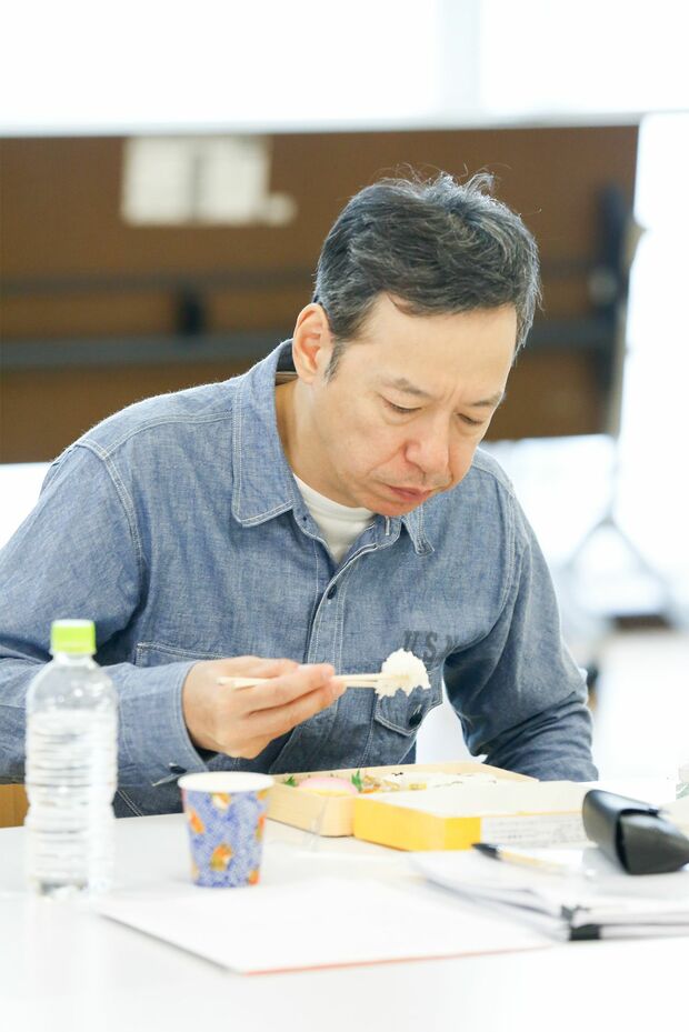 シュウマイ弁当を黙々とかきこむ板尾。「お笑いはひとりでもできるけど、映画監督は多くのスタッフを納得させて動かさなくてはいけない」と監督業の難しさを。「シリアスな役よりコメディーのほうが難しいと思いますよ。コメディーは面白いか、面白くないかで評価がはっきり分かれますから」とお笑い出身のプライドもにじませた。撮影／森田晃博