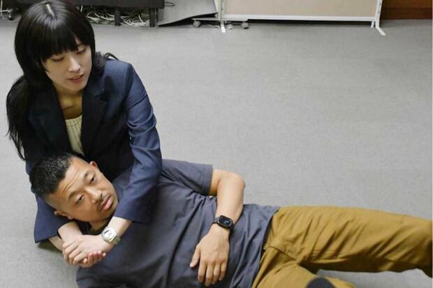 9月30日、感謝状を受け取った際、警察官を相手にヘッドロックを再現した梁さん